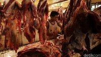 Pedagang memotong daging sapi menjadi kecil-kecil.