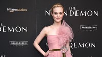 Aktris berusia 18 tahun itu tampil dengan gaun panjang berwarna pink dilengkapi oleh ikat pinggang berwarna hijau dan hiasan bunga. Dimitrios Kambouris/Getty Images/detikFoto.