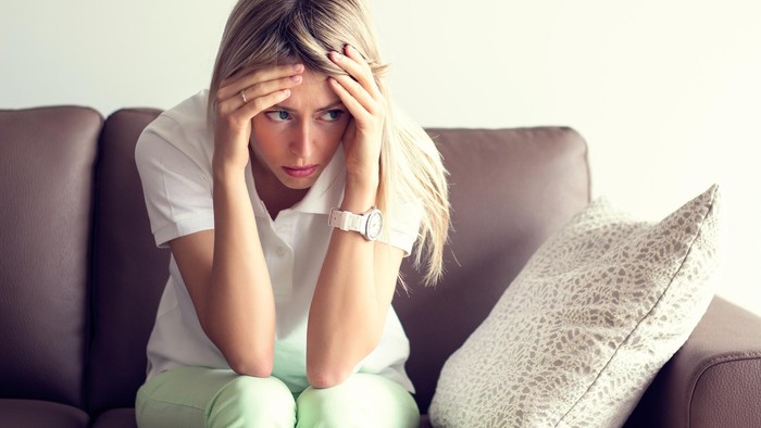 Ilustrasi Wanita Bingung Sad young woman sitting on couch in depression.