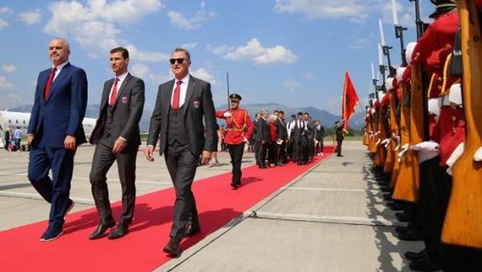Albanian Prime Minister Edi Rama (L), the captain of Albanias national soccer team, Lorik Cana (C) and Albanias national football team head coach Gianni De Biasi review an honor guard during a welcoming ceremony at Mother Teresa airport in Tirana on June 23, 2016. 
Albanias Euro 2016 squad was welcomed home on June 23 with a formal red-carpet ceremony and National Guard troops on its return from the countrys first ever participation at a European Championship. / AFP PHOTO / GENT SHKULLAKU