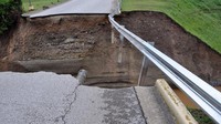 Banjir menyebabkan jalan terbelah. West Virginia Department of Transportation/Handout via Reuters .