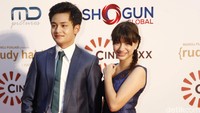 Cassie tampil cantik dengan dress biru sedangkan Randy mengenakan setelan jas warna serupa.