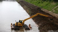 Petugas mengangkat tanah yang mengendap di dasar sungai.