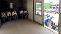 Pekerja memasukkan motor ke gerbong kereta.
