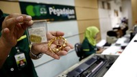 Seorang petugas menunjukan emas yang digadaikan oleh nasabah di kantor Pegadaian Pusat, Jakarta, Selasa (28/6/2016).