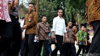 Jokowi berjalan menuju perkampungan warga yang berada di pinggir anak kali CIliwung.
