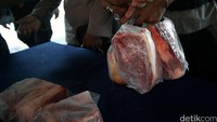 Warga membawa daging yang baru dibelinya.