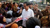 Jokowi membagikan buku tulis kepada anak-anak di pinggir kali Jl Inspeksi Kramat Kembang, Kwitang, Senen, Jakarta Pusat.