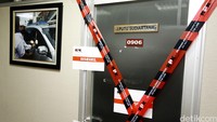 Pintu masuk ke ruangan Putu disegel dengan garis KPK (KPK Line) melintang membentuk huruf X dan kertas bertuliskan Disegel.