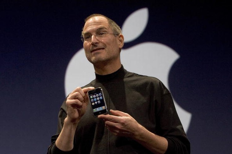Steve Jobs SAN FRANCISCO, CA - JANUARY 9: Apple CEO Steve Jobs holds up the new iPhone that was introduced at Macworld on January 9, 2007 in San Francisco, California. The new iPhone will combine a mobile phone, a widescreen iPod with touch controls and a internet communications device with the ability to use email, web browsing, maps and searching. The iPhone will start shipping in the US in June 2007. (Photo by David Paul Morris/Getty Images)