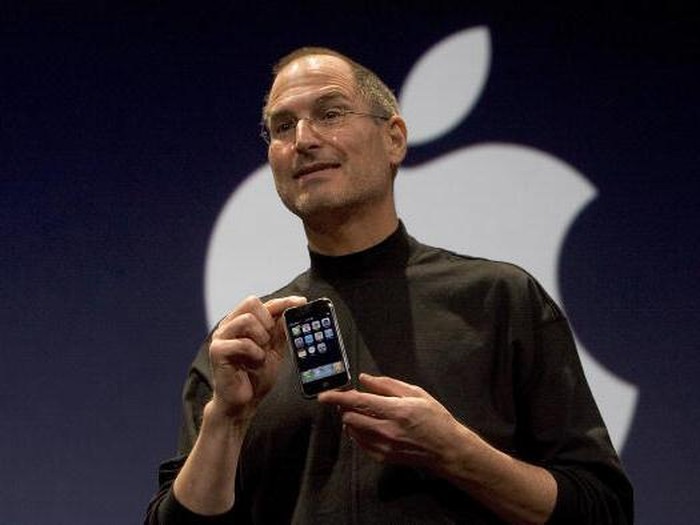 Steve Jobs memegang iPhone generasi pertama. Foto: Getty Images Steve Jobs memegang iPhone generasi pertama. Foto: Getty Images