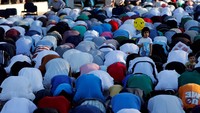 Seorang anak kecil tampak berdiri memegang sebuah balon di tengah shaf jamaah yang sedang melaksanakan salat Id di Amman, Yordania. Muhammad Hamed/Reuters