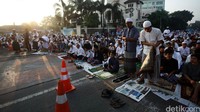 Jamaah tampak menggelar sajadah mereka di jalanan kawasan Kebon Pala. 
