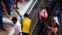Para pemudik berusaha keras memanjat ke atap kereta. Adnan Abidi/Reuters
