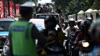 Polisi ikut mengamankan antrean di pintu masuk Ragunan. 