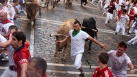 Para pengunjung tampak panik saat berlari bersama banteng di Festival San Fermin, Spanyol (7/7/2016). Vincent West/Reuters/detikFoto