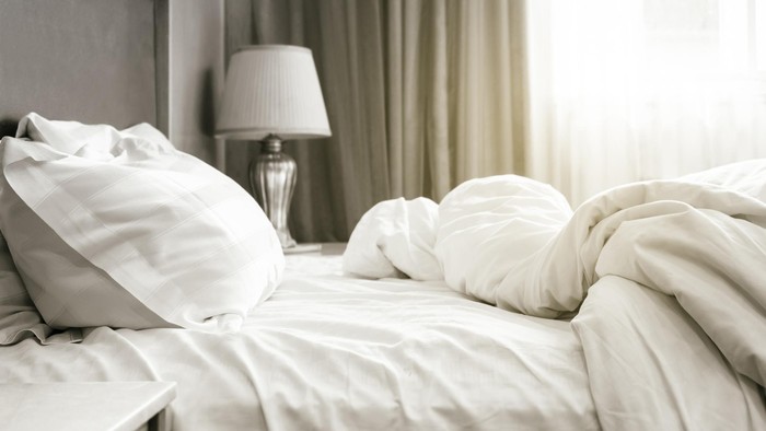 Bed sheet mattress Duvet and pillows unmade Bedroom interior