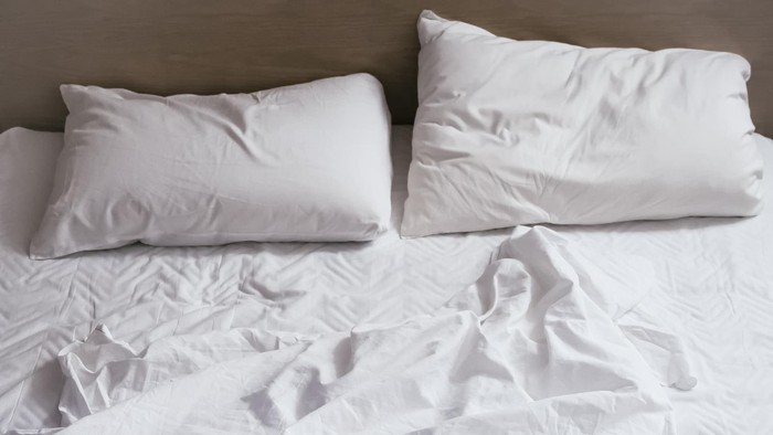 Bed sheet mattress Duvet and pillows unmade Bedroom interior