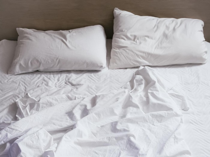 Bed sheet mattress Duvet and pillows unmade Bedroom interior