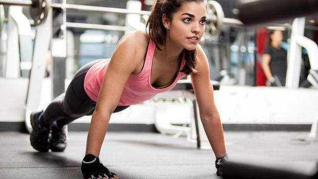 459880391 Gorgeous brunette warming up and doing some push ups a the gym