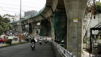Pengendara melintas di bawah proyek pembangunan jembatan layang (flyover) di Jalan Kapten P. Tendean, Jakarta Selatan, Selasa (13/07/2016).