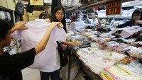Beberapa pelajar memilih seragam sekolah di kawasan Pasar Baru, Jakarta Pusat.