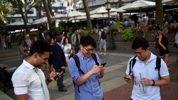 Tiga sahabat sama sama bermain Pokemon Go di sebuah taman. Foto: Reuters