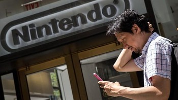 Seorang pria berburu Pokemon di depan toko Nintendo. Foto: Reuters