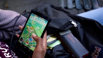 Wanita ini memakai powerbank agar bisa main Pokemon Go lebih lama. Foto: Reuters