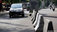 Sebuah mobil mencoba melawan arah saat petugas Dishub DKI Jakarta sedang memasang pembatas jalan.