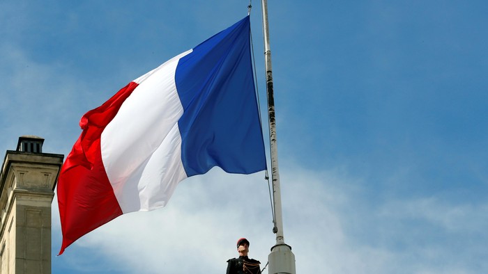A Republican Guard pays respects after lowering the French national flag at half-mast at the Elysee Palace in Paris, France, July 15, 2016, the day after the Bastille Day truck attack in Nice. REUTERS/Philippe Wojazer