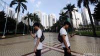 Sambil memegang HP, mereka menatap ke layar dan membuka aplikasi game Pokemon GO.