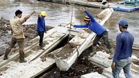 Para pekerja melakukan pemasangan turap di bantaran Ciliwung, Bukit Duri Kampung Melayu, Jakarta, Senin (18/07/2016).