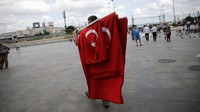 Seorang warga menjajakan bendera Turki di Istanbul. REUTERS/Alkis Konstantinidis.