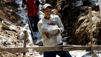 Seorang pekerja memasang pondasi saluran air.