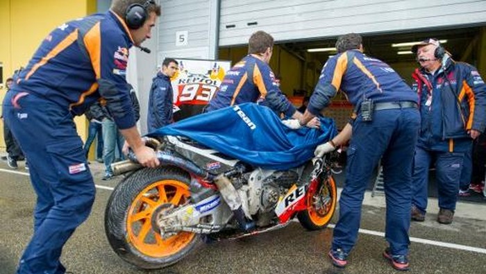 Team members of Honda rider Marc Marquez of Spain return the bike to the box after a crash during the warm-up, prior to the Moto GP race of the Grand Prix of Germany, at the Sachsenring Circuit, on July 17, 2016, in Hohenstein-Ernstthal, eastern Germany.

 / AFP PHOTO / Robert MICHAEL