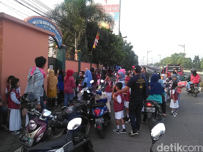 Orang tua murid antar anak di SDN Babakan Surabaya Selatan