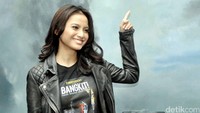 Meski berdandan a la rocker, senyum manisnya masih mampu meluluhkan hati para pria. Pool/Noel/detikFoto.