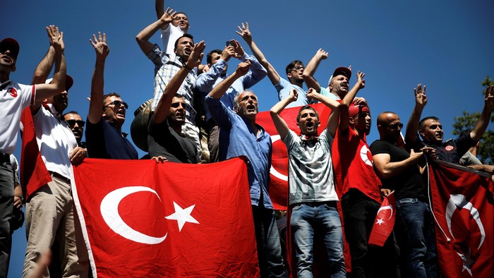 Supporters hold a banner with a photo of Turkish President Tayyip Erdogan during a pro-government demonstration in Sarachane park in Istanbul, Turkey, July 19, 2016. REUTERS/Alkis Konstantinidis