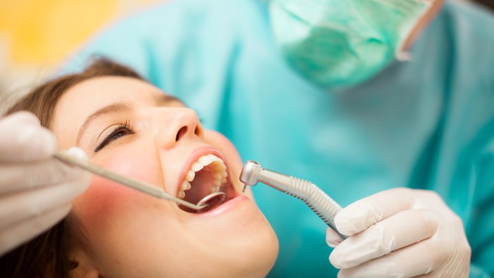 453555057 Dentist doing a dental treatment on a female patient