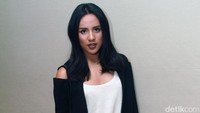 Ia tak segan memamerkan bahunya lewat outter hitam dengan kaos putih, serta jeans dan heels hitam. Pool/Gus Mun/detikFoto.