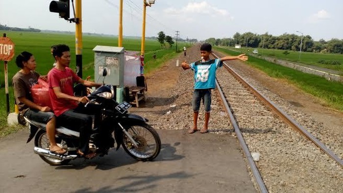 Mengintip Aktivitas Bocah Penjaga Perlintasan Tanpa Palang Pintu