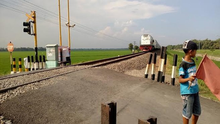 Doni Mengais Rezeki Jaga Perlintasan, Hasilnya Ditabung dan Belanja Ibu