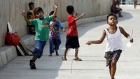 Sejumlah anak asyik bermain di jalan di kawasan Bukit Duri, Jakarta.