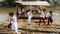 Sejumlah anak SD menggunakan perahu eretan untuk menyebrangi sungai ciliwung di Bukit Duri, Jakarta, Rabu (20/017/2016).