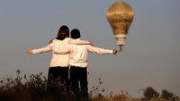 Sepasang kekasih tampak sedang melihat festival balon raksasa yang digelar selama dua hari tersebut. Amir Cohen/Reuters/detikFoto