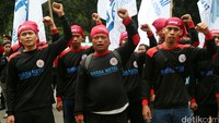 Buruh berorasi sambil mengepalkan tangan.