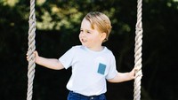 George yang mengenakan busana bernuansa biru tampak berdiri di atas ayunan yang bertuliskan William & Catherine. (Twitter/KensingtonRoyal)