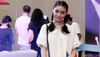 Citra Kirana tampil dengan rambut dikepang dua, blus putih dan celana pendek jeans.