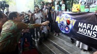 Saut Situmorang melemparkan bola Pokemon pada spanduk aksi Tangkap Makumon.